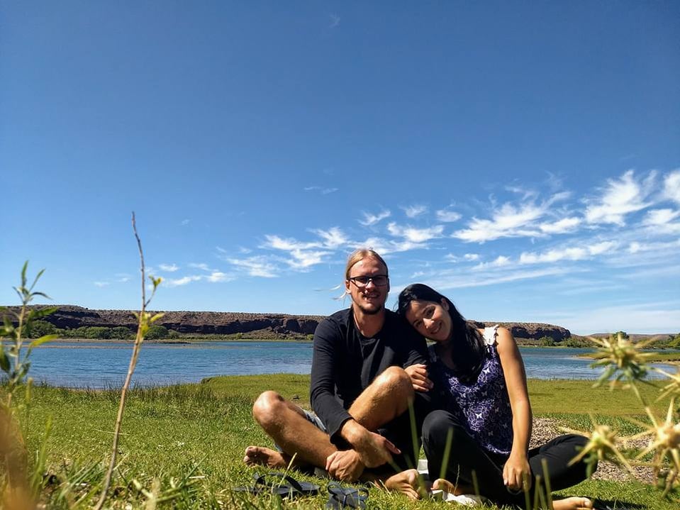 A man and a woman sitting in front a river